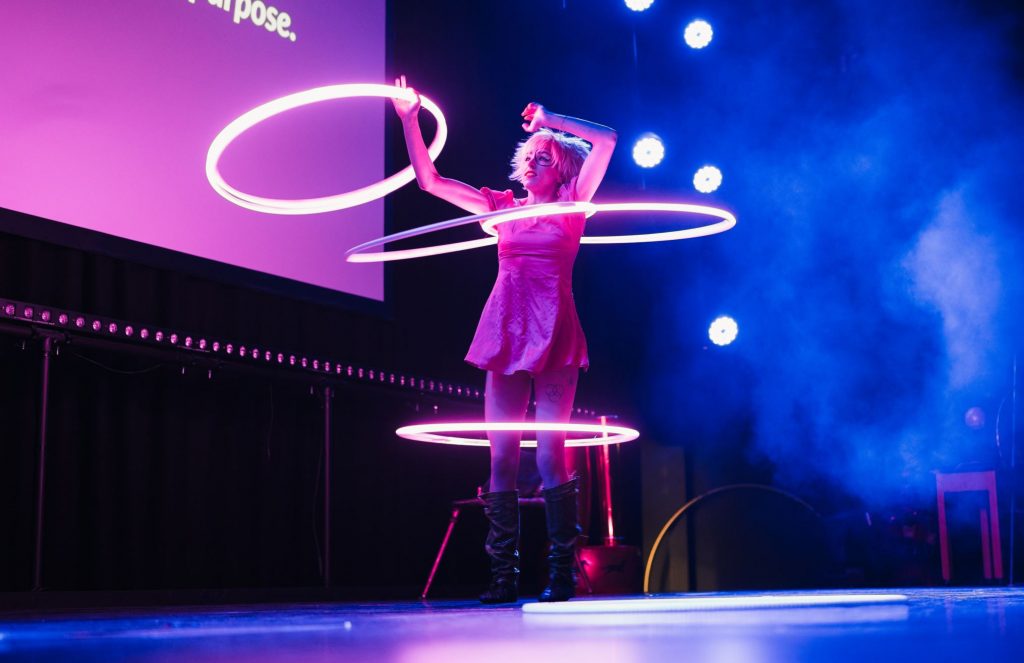 A woman is using light up hula hoops aka sensory hoops