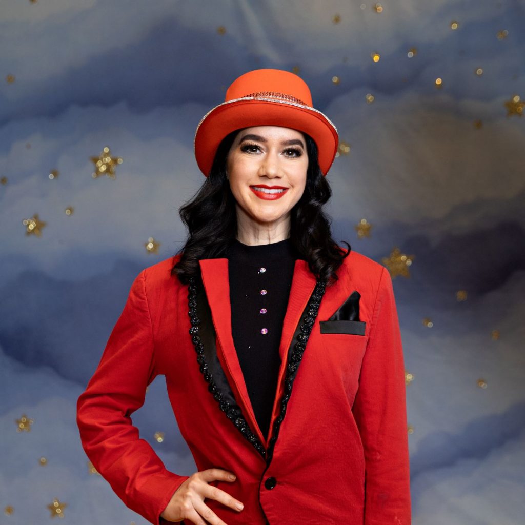 A lady is wearing a red ringmistress outfit